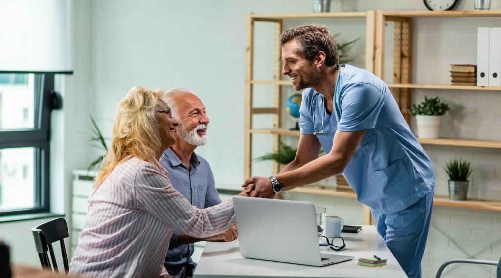 doctor feliz saludando pareja mayor estrechando mano mujer su oficina scaled