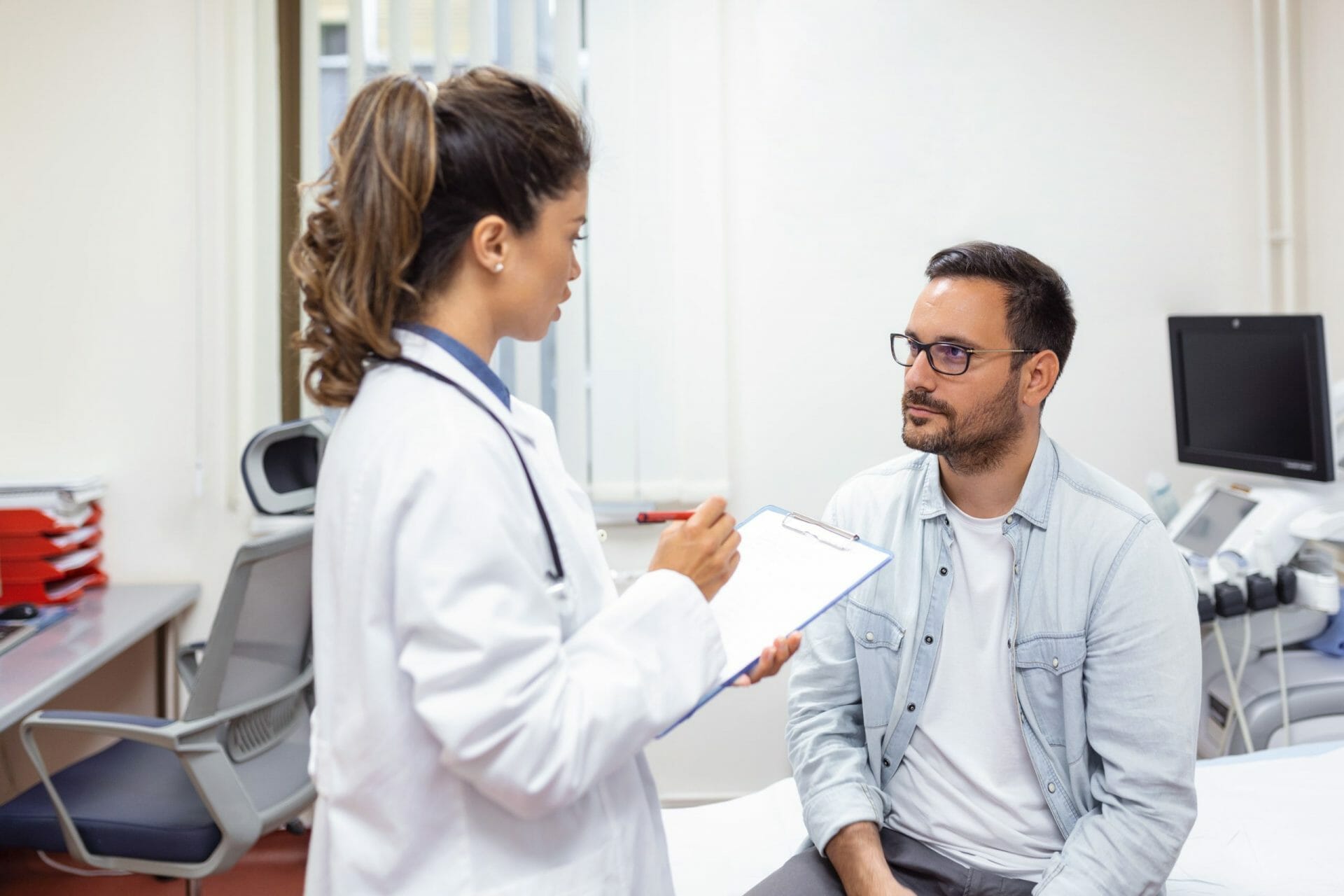 Especialistas hombre serio consultando joven medica reunion control hospital medico general calificado que da consejos medicos salud al paciente scaled